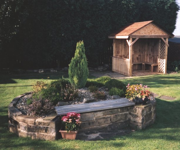 gazebo in garden with raised bed to the foreground